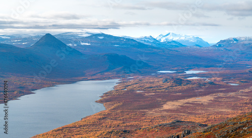 Epic view of vast arctic landscape of Stora Sjofallet National Park, Sweden, on autumn day. Remote mountains and valleys of Lapland. Ahkka massif in the back. View from the top of Lulep Gierkav.
