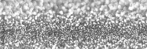 Silver sparkling glitter bokeh background, christmas texture. Holiday lights. Abstract defocused header. Wide screen wallpaper. Panoramic web banner with copy space for design