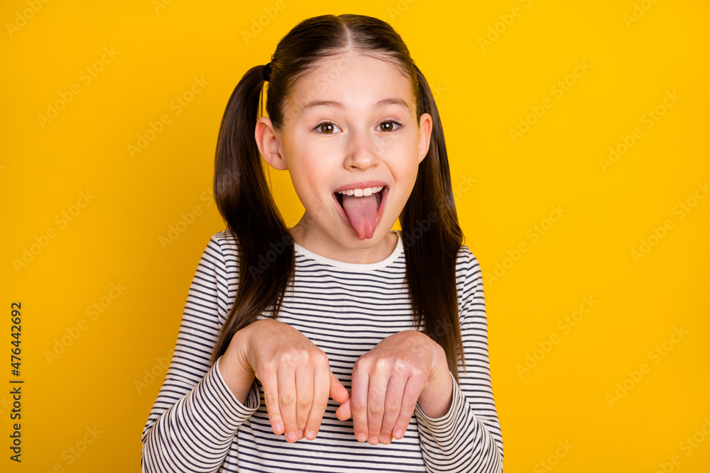 Photo of young girl happy positive smile grimace tongue-out hold hands dog isolated over yellow color background - obrazy, fototapety, plakaty 