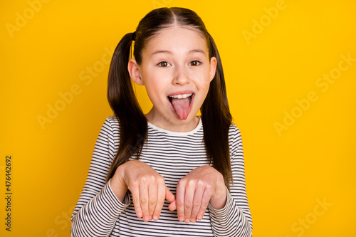 Photo of young girl happy positive smile grimace tongue-out hold hands dog isolated over yellow color background