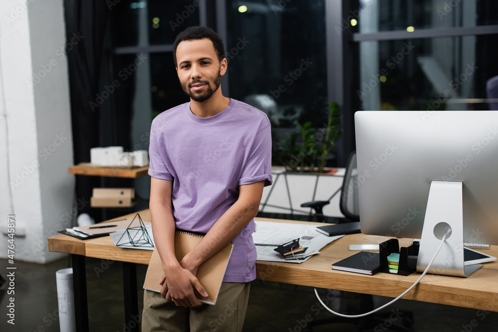 bearded african american manager holding notebook in modern office.