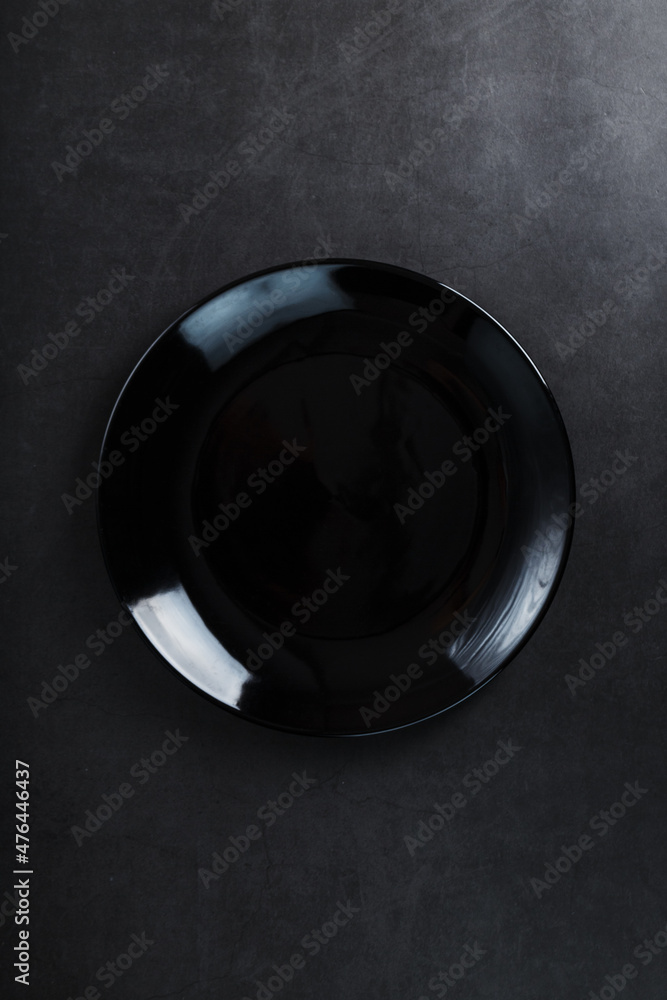 Black plate on a black background top view.