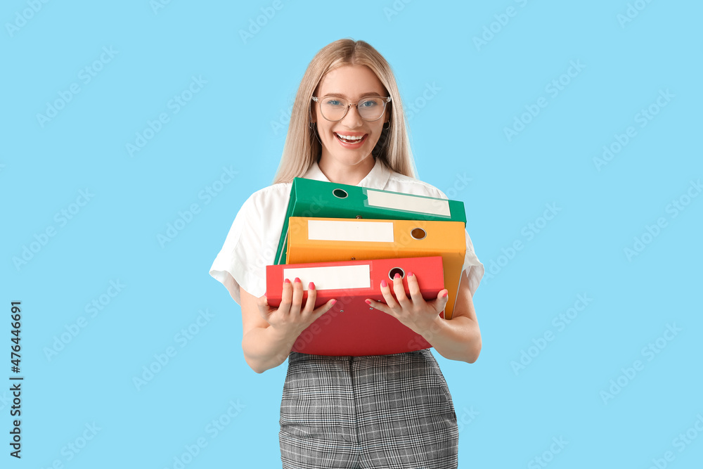 Pretty young woman with folders on blue background Pretty young woman with folders on blue background