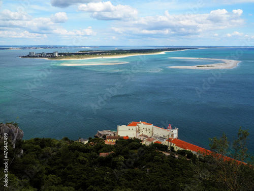Aerial view of scenic seascape with lighthouse overlooking peninsula and sand banks.