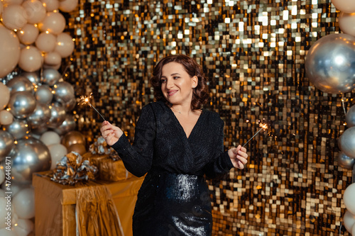 Fotografía beautiful young woman in a stunning black dress with sparklers Party New Years
