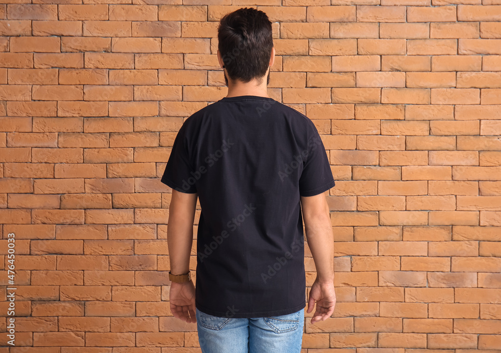 Handsome man in black t-shirt on brick background Handsome man in black t-shirt on brick background
