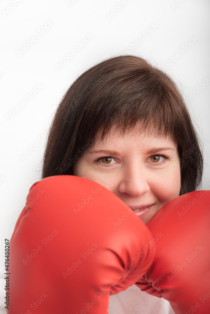 Close-up portrait of young dark-haired woman in red wrestling gloves. Woman boxer. Vertical frame Close-up portrait of young dark-haired woman in red wrestling gloves. Woman boxer. Vertical frame