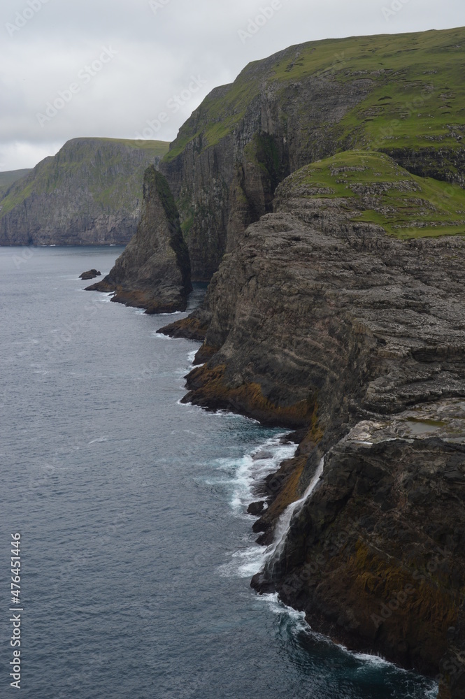 The green and blue dramatic and wild coastal landscapes in the Faroe Islands