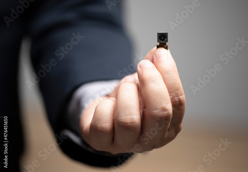 Legal security, pinhole camera, privacy of Personal Information , businessman holding pinhole camera in hand.