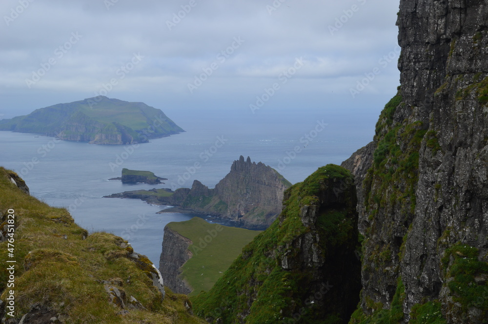 Fototapeta premium The green and blue dramatic and wild coastal landscapes in the Faroe Islands
