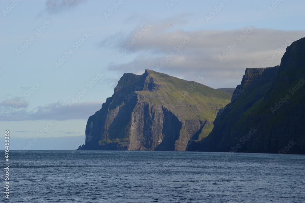 The green and blue dramatic and wild coastal landscapes in the Faroe Islands The green and blue dramatic and wild coastal landscapes in the Faroe Islands