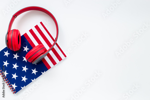 USA flag on notebook with headphones. E-learning language concept