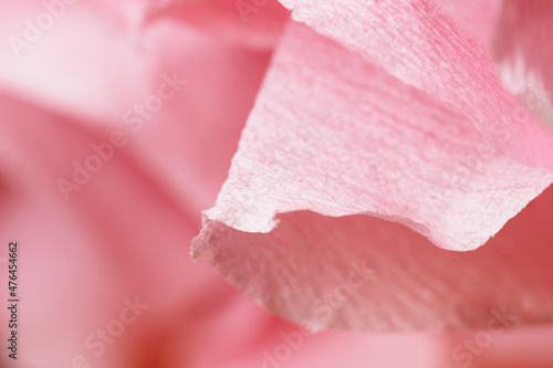 Fragment of a light pink flower made of crepe paper. Macro photography. Soft selective focus