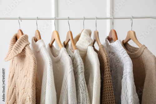 Stylish sweaters on hanger in dressing room