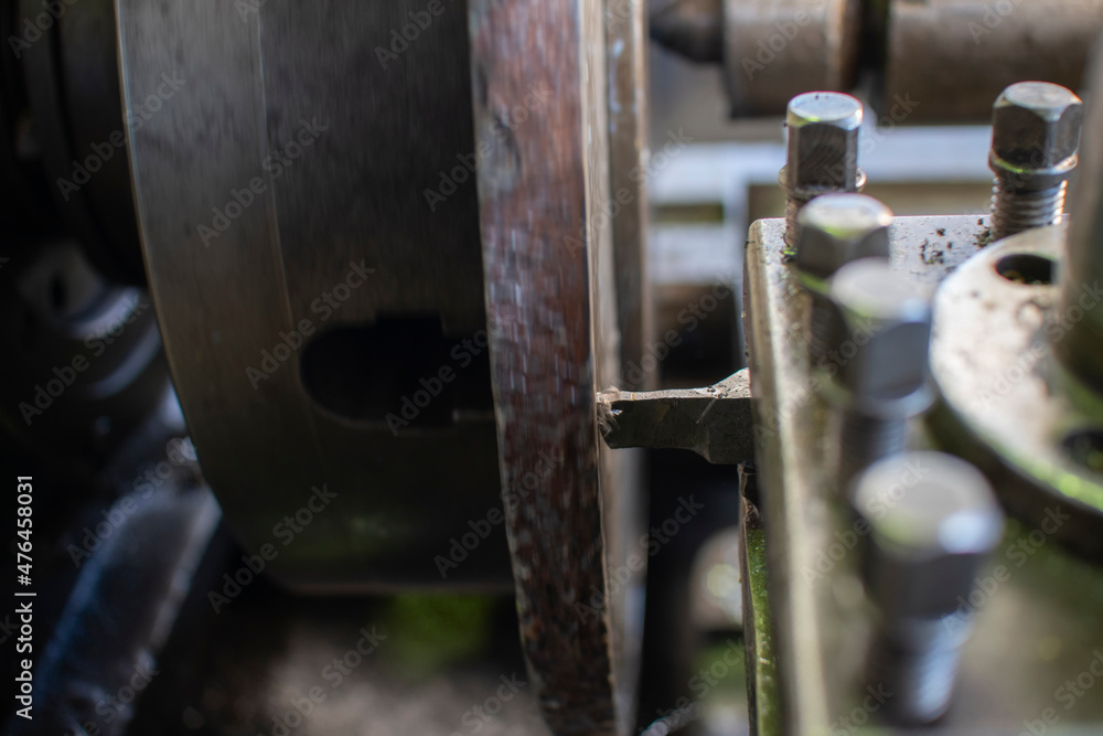 The lathe machine processes a cylindrical part clamped in a chuck. The lathe machine processes a cylindrical part clamped in a chuck.