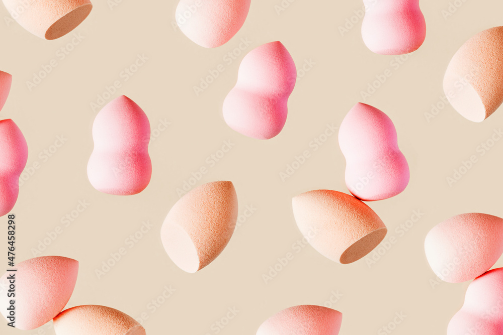 Pattern with cosmetic sponge pink beige colored. Soft makeup sponge beauty blender, brush for face skin, facial applicator. Backgrounds for salon fashion beauty makeup