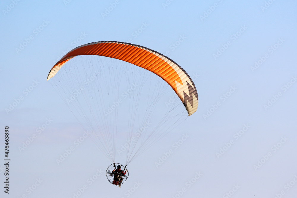 Paramotor pilot flying in a blue sky Paramotor pilot flying in a blue sky