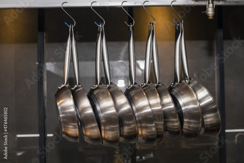 Many pans hanging in a restaurant kitchen.