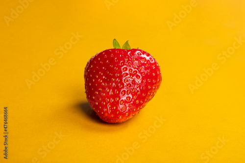 red juicy strawberry berry on a yellow background