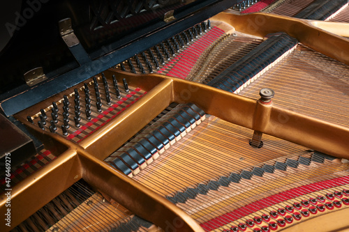 Inside a grand piano, metal frame, strings and mechanics of the old acoustic musical instrument, music themes, selected focus