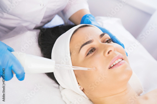 Close up photo of a happy woman receiving rejuvenation cosmetology procedure non injection mesotherapy.