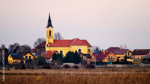 Velky Biel village landscape in Slovakia with field, houses and church photo