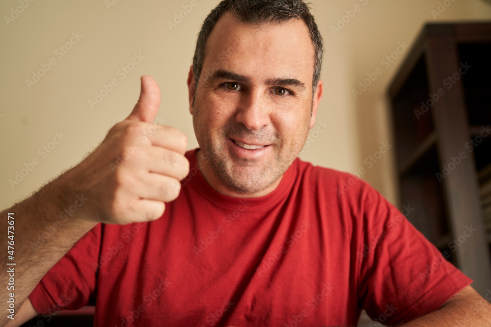 © Retamosa - A friendly man waving during a video call, as seen on a device screen