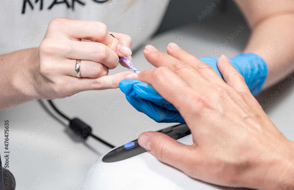 Performing manicure work in a beauty salon.