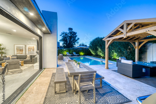 Outdoor table and chairs by the pool at sunset © Allison