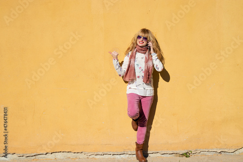 woman with mobile phone isolated on the wall outdoors