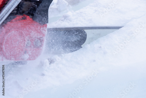 A worker is cutting ice with a chainsaw.