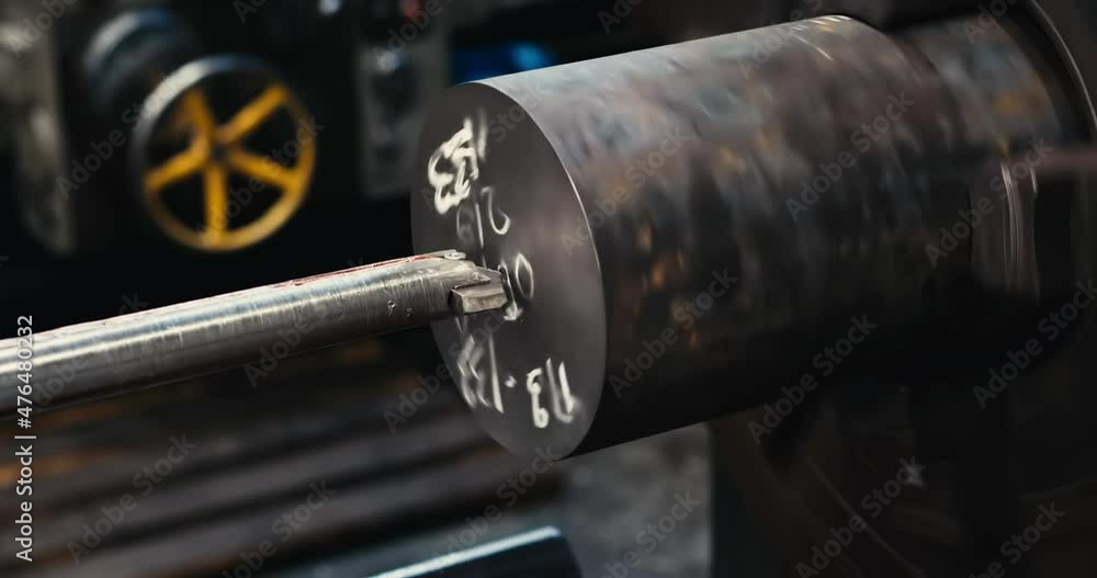 A close-up of a metal workpiece clamped in a rotating chuck of a machine tool. Steel drill and shavings. Detail of drilling on a lathe with metal shavings. A close-up of a metal workpiece clamped in a rotating chuck of a machine tool. Steel drill and shavings. Detail of drilling on a lathe with metal shavings.