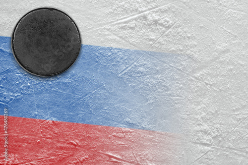 Hockey puck lying on the ice of the arena with the image of the Russian flag