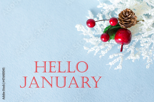 Hello January inscription on a gob background next to the Christmas decoration photo