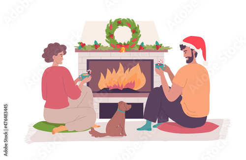 Romantic Christmas family celebrating with hot drinks sitting at the fireplace 