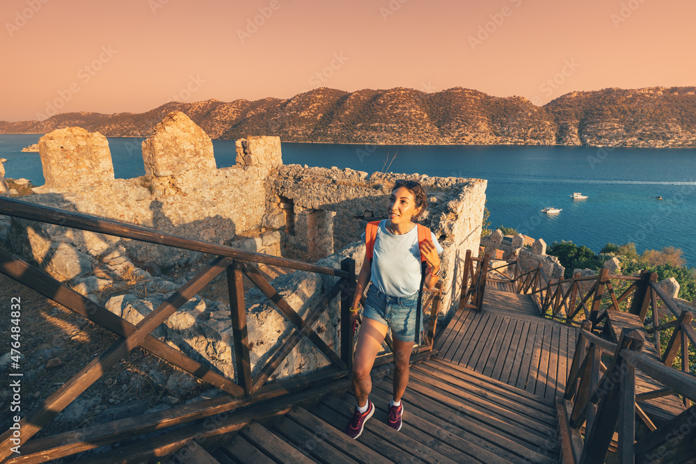 Φωτογραφία Woman traveler explores the ruins of the castle of Simena with a view of the sea bay and Kekova Island with the famous flooded city