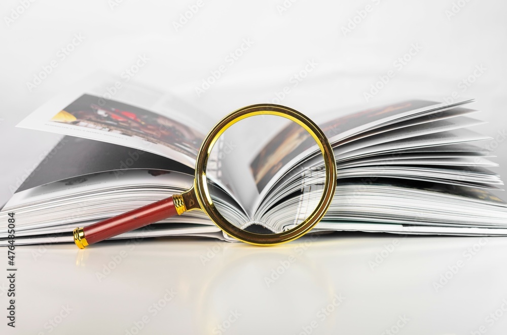 Magnifier and open paper book. Concept of academic research, investigation, studying, getting knowledge. Magnifier and open paper book. Concept of academic research, investigation, studying, getting knowledge.