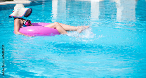 Mysterious woman swims on a rubber inflatable ring in the pool