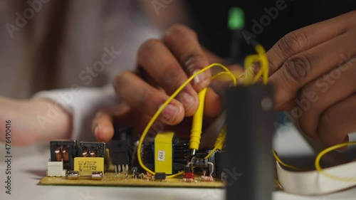Technician touches diodes with probes showing little student photo