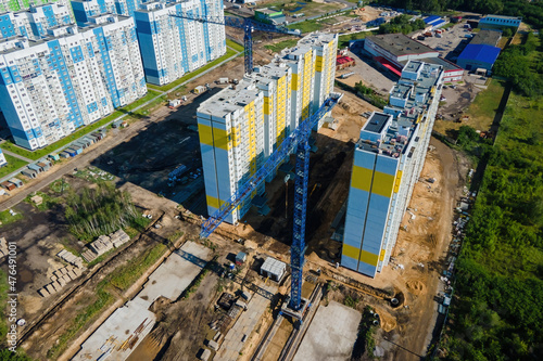 Construction jib crane tower at construction site of new residential building. Aerial view.