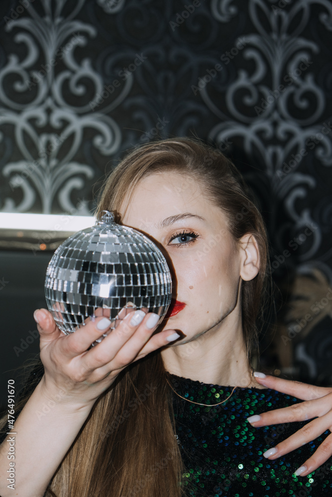 Nightlife, New year eve party, New year celebration. Portrait of young beautiful woman and disco ball Nightlife, New year eve party, New year celebration. Portrait of young beautiful woman and disco ball