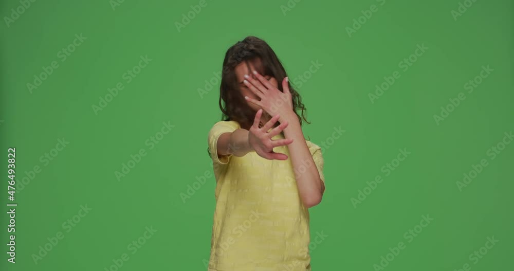 Young girl covering eyes with hands doing stop gesture with fear expression, feel disgust on chromakey green background Young girl covering eyes with hands doing stop gesture with fear expression, feel disgust on chromakey green background