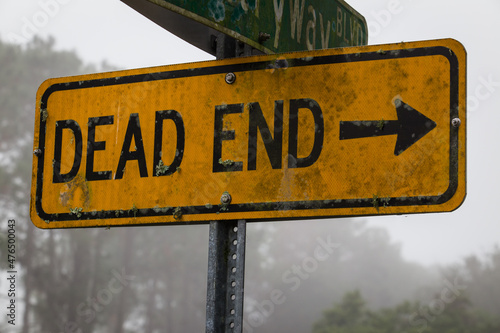 A rectangle dead end sign in a foggy morning.