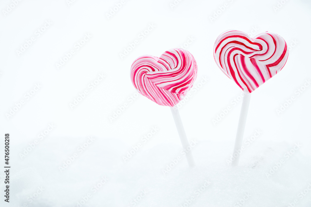 Two pink heart-shaped lollipop. Caramel candy on stick on white background. Sweet gift for valentines day. Two pink heart-shaped lollipop. Caramel candy on stick on white background. Sweet gift for valentines day.
