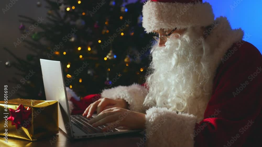 Santa claus is typing a letter on the computer. Santa claus is typing a letter on the computer.