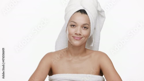 Funny good-looking young slim African American woman with a towel on her hair throws away orange razor on white background | Unwanted body hair removal concept