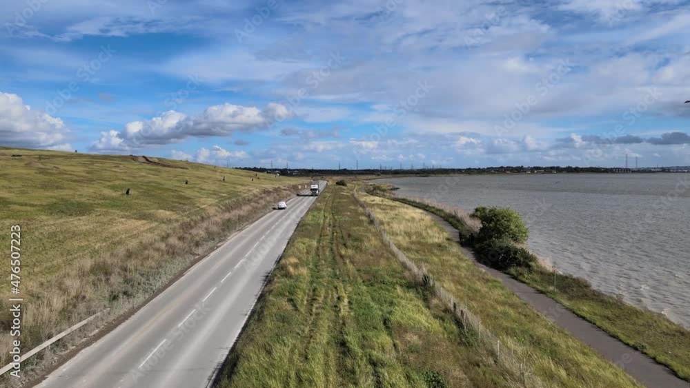 grassland countryside near River Thames bank. Truck driving on road in long turn. grassland countryside near River Thames bank. Truck driving on road in long turn.
