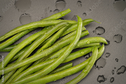 Fotografie Green beans sit on a slate cutting board after being trimmed and washed