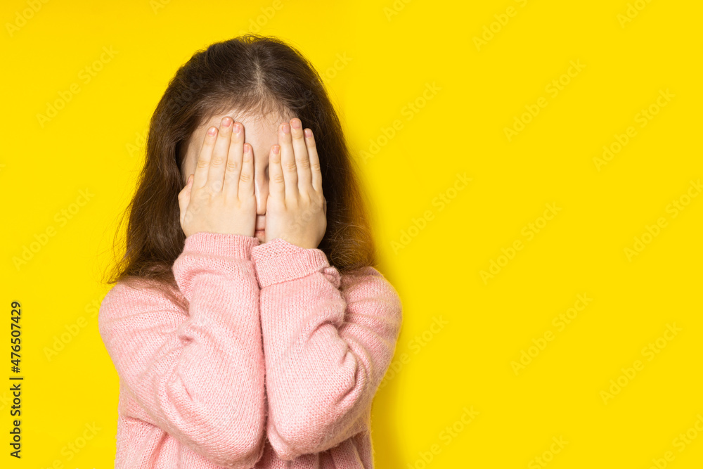 custom made wallpaper toronto digitalScared girl. Fearful little girl covered her face with her hands on a yellow background.