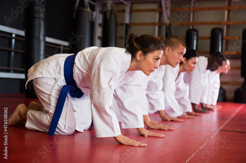Training a group of athletes before karate training - push-ups and muscle warm-up